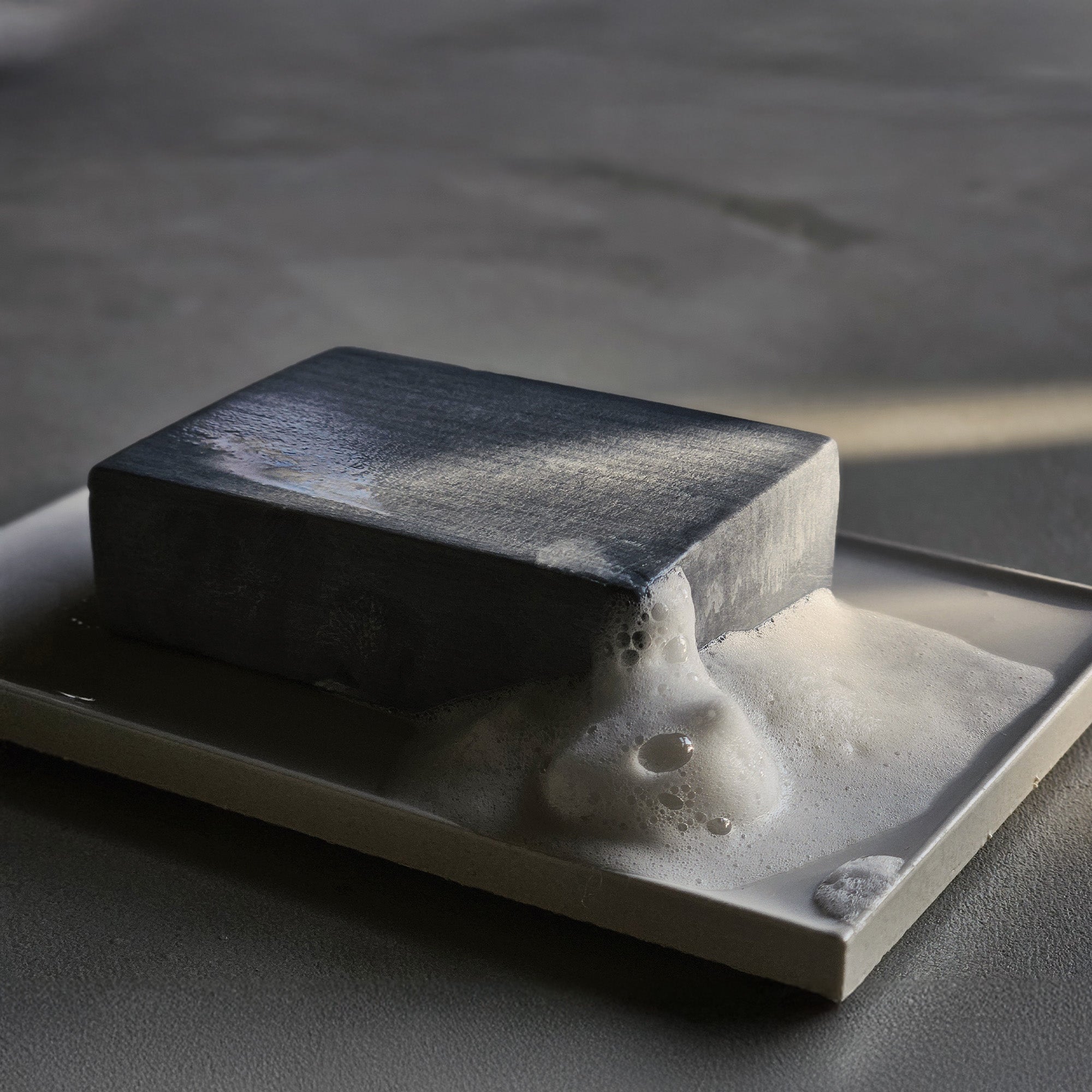 石けん皿に置かれた「竹と森の未來石けん」の本体と、そこから溢れ出す濃密できめ細かな白い泡