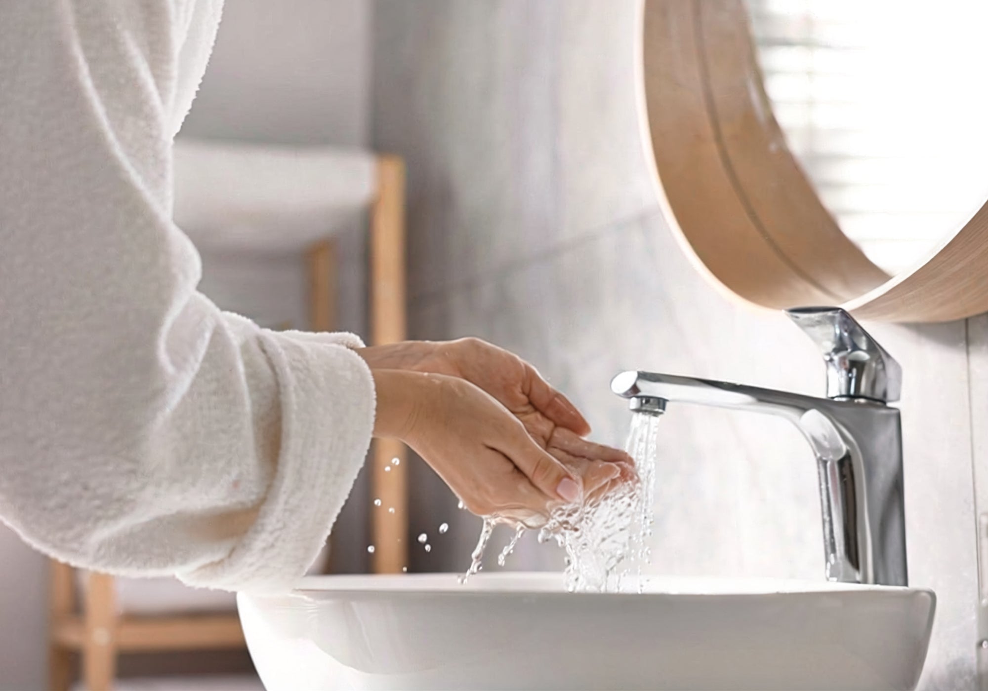 洗面台で顔を洗う女性の手元
